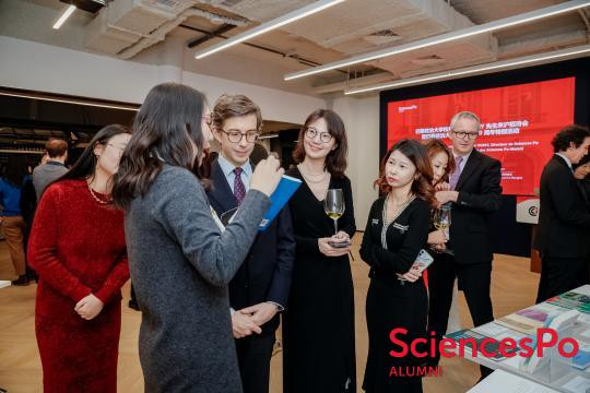 A group of people standing around a table
AI-generated content may be incorrect.
